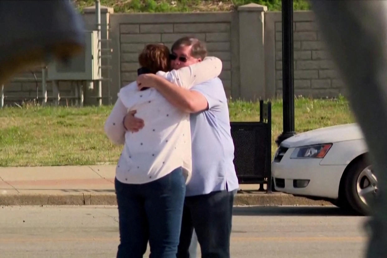 Louisville residents console each other outside the Old National Bank following Monday's mass shooting