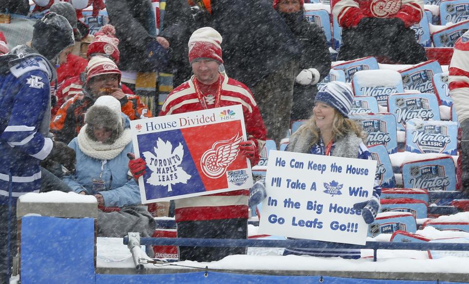 Hockey fans hold up signs during the first period of the Winter Classic outdoor NHL hockey game between the Detroit Red Wings and the Toronto Maple Leafs at Michigan Stadium in Ann Arbor, Mich., Wednesday, Jan. 1, 2014. (AP Photo/Paul Sancya)