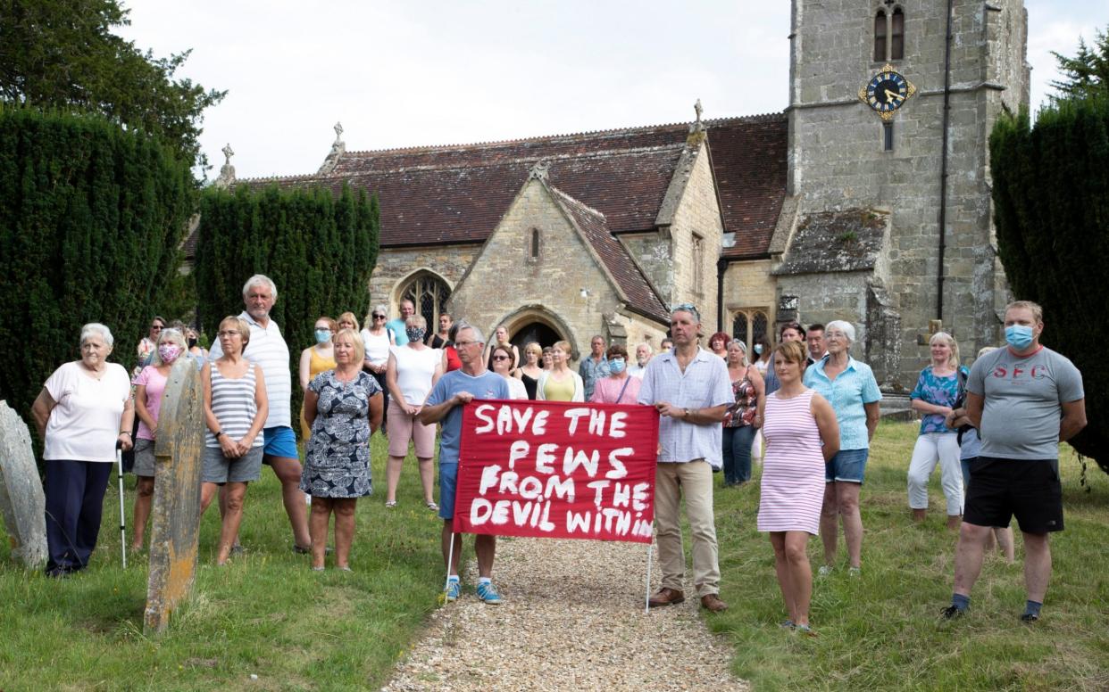 Parishioners gather to protest in the grounds of the Grade II listed St Andrew's Church in the Dorset village of Okeford Fitzpaine -  BNPS
