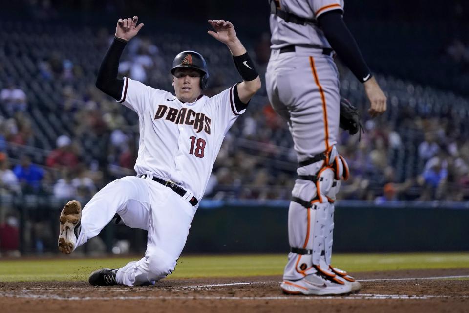 Arizona Diamondbacks' Carson Kelly (18) scores a run against the San Francisco Giants during the third inning of a baseball game, Thursday, Aug. 5, 2021, in Phoenix. (AP Photo/Ross D. Franklin)