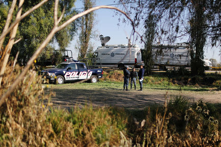 Federal police officers keep watch at the site where a fuel pipeline, ruptured by suspected oil thieves, exploded in the municipality of Tlahuelilpan, state of Hidalgo, Mexico January 22, 2019. Picture taken January 22, 2019. REUTERS/Mohammed Salem