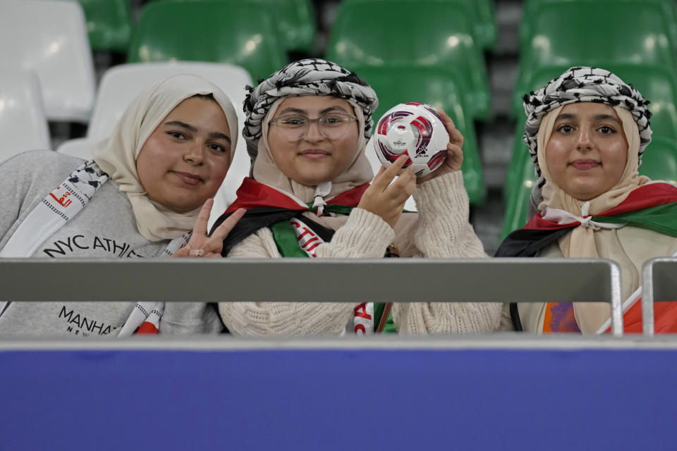 Young Palestine supporters, one holding a mini soccer ball, wait for the start of the Asian Cup Group C soccer match between Iran and Palestine at the Education City Stadium in Al Rayyan, Qatar, Sunday, Jan. 14, 2024. (AP Photo/Aijaz Rahi)