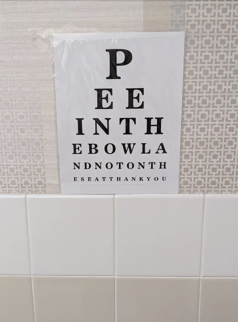 Eye chart-themed sign with the message: "PEE IN THE BOWL AND NOT ON THE SEAT THANK YOU."