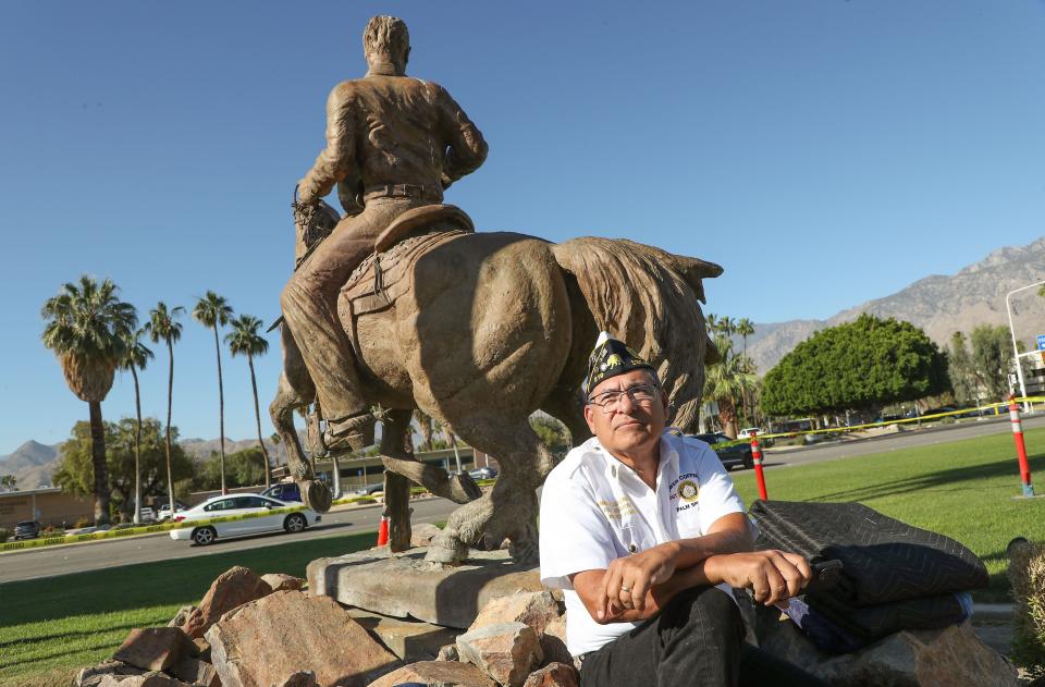 Amado Salinas II sits while protesting the removal of the Frank Bogert statue at Palm Springs City Hall in Palm Springs, Calif., May 17, 2022.  Officials decided not to remove the statue while Salinas was sitting there in protest on Tuesday.