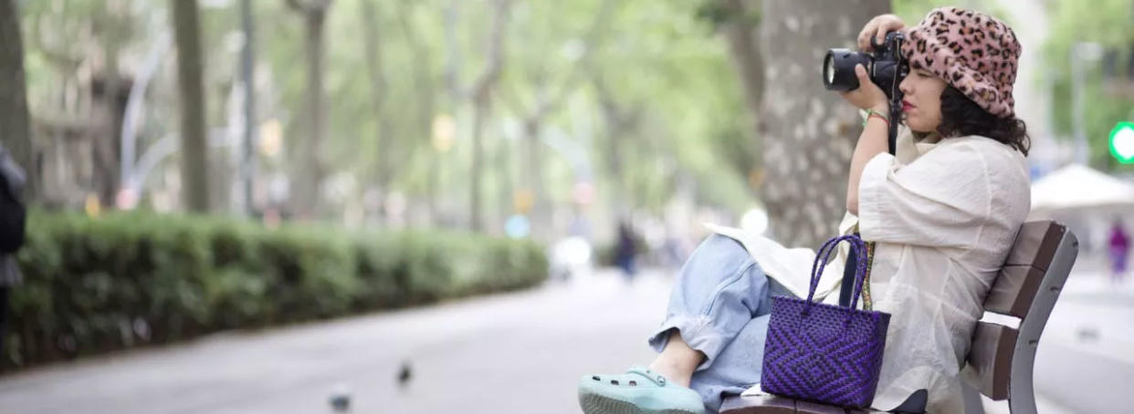  Woman sitting on a bench using an MPB camera 