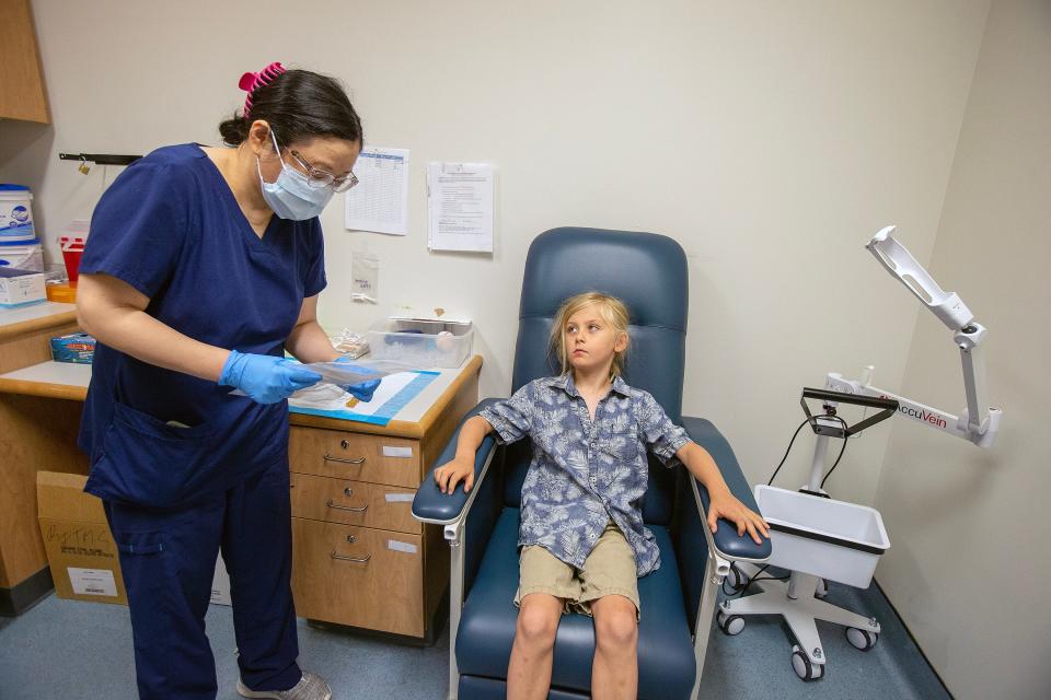 Seamus Naughton Mergner, 7, of Allentown participates in the Lyme disease clinical trial at the Pediatric Clinical Research Center, which is an academic clinical research center within the Department of Pediatrics at Rutgers Robert Wood Johnson Medical School, at the Child Health Institute of New Jersey in New Brunswick, NJ Thursday June 29, 2023. Fei Chen, RN, administers the injection.