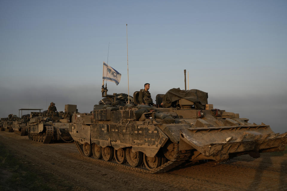 A convoy of Israeli army armoured personnel carriers (APC) is seen near the Israeli-Gaza border, in southern Israel, Monday, Dec. 25, 2023. The army is battling Palestinian militants across Gaza in the war ignited by Hamas' Oct. 7 attack into Israel. (AP Photo/Leo Correa)