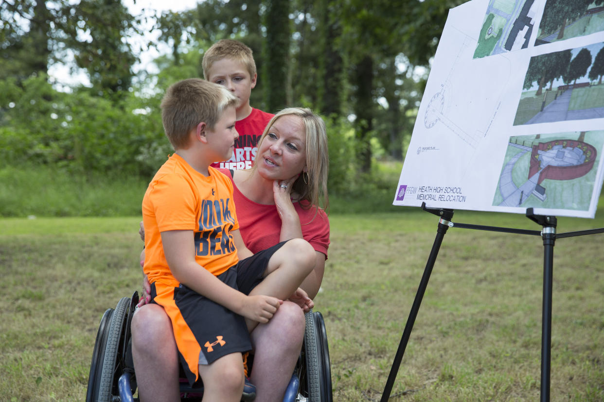 Missy Jenkins Smith, who was shot during the Heath High School shooting in 1997 and paralyzed from the chest down, talks to her sons, Carter Smith, 7, and Logan Smith, 9, about the shooting. (Photo: Ryan Hermens/The Paducah Sun via AP)