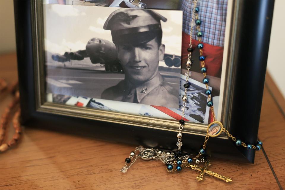 Rosary beads hang from a photograph of John Connelly at 18, taken as he trained in the Army Air Corps.