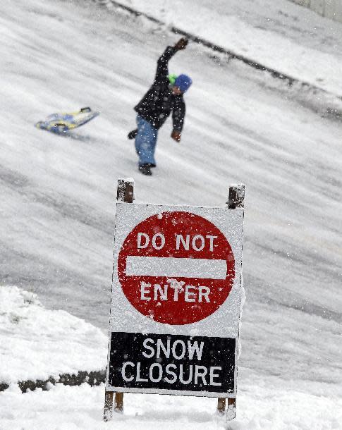 A child flips off of a sled on a street closed to traffic but open for play during a winter storm moving through the area, Monday, Feb. 6, 2017, in Seattle. Seattle finally got its dose of winter weather, with an overnight storm that left snow totals of an inch to more than a foot across western Washington, causing widespread school closures Monday. (AP Photo/Elaine Thompson)