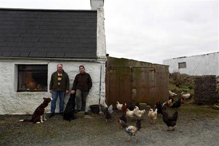 Ian Tomkinson, 57 (L), and Jo Tomkinson, 48, poses for a photograph beside their house near the village of Sandness on the Shetland Islands April 1, 2014. REUTERS/Cathal McNaughton