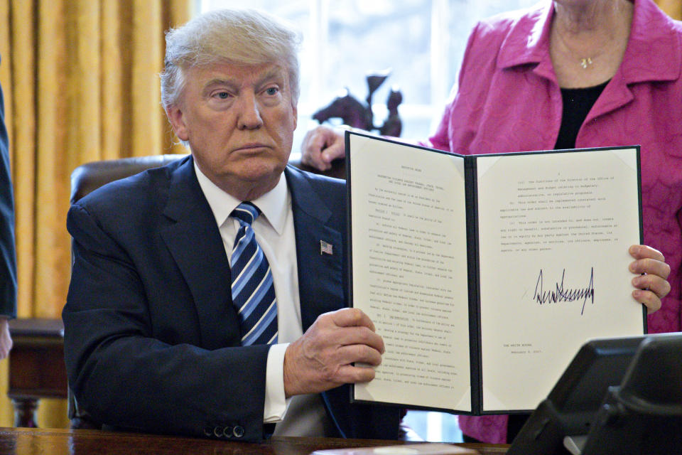 Trump holds up a signed executive order entitled "Preventing Violence Against Federal, State, Tribal and Local Law Enforcement Officers" in the Oval Office on Feb. 9, 2017.&nbsp;