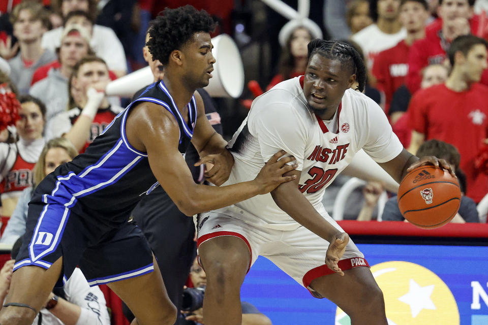 North Carolina State's DJ Burns Jr. (30) tries to drive the ball through Duke's Sean Stewart, left, during the first half of an NCAA college basketball game in Raleigh, N.C., Monday, March 4, 2024. (AP Photo/Karl B DeBlaker)