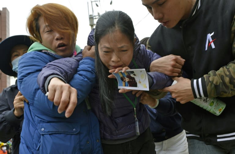 A mother holds a picture of her son after a male student body was recovered from the Wei-Kuan complex which collapsed in the 6.4 magnitude earthquake, in the southern Taiwanese city of Tainan on February 10, 2016