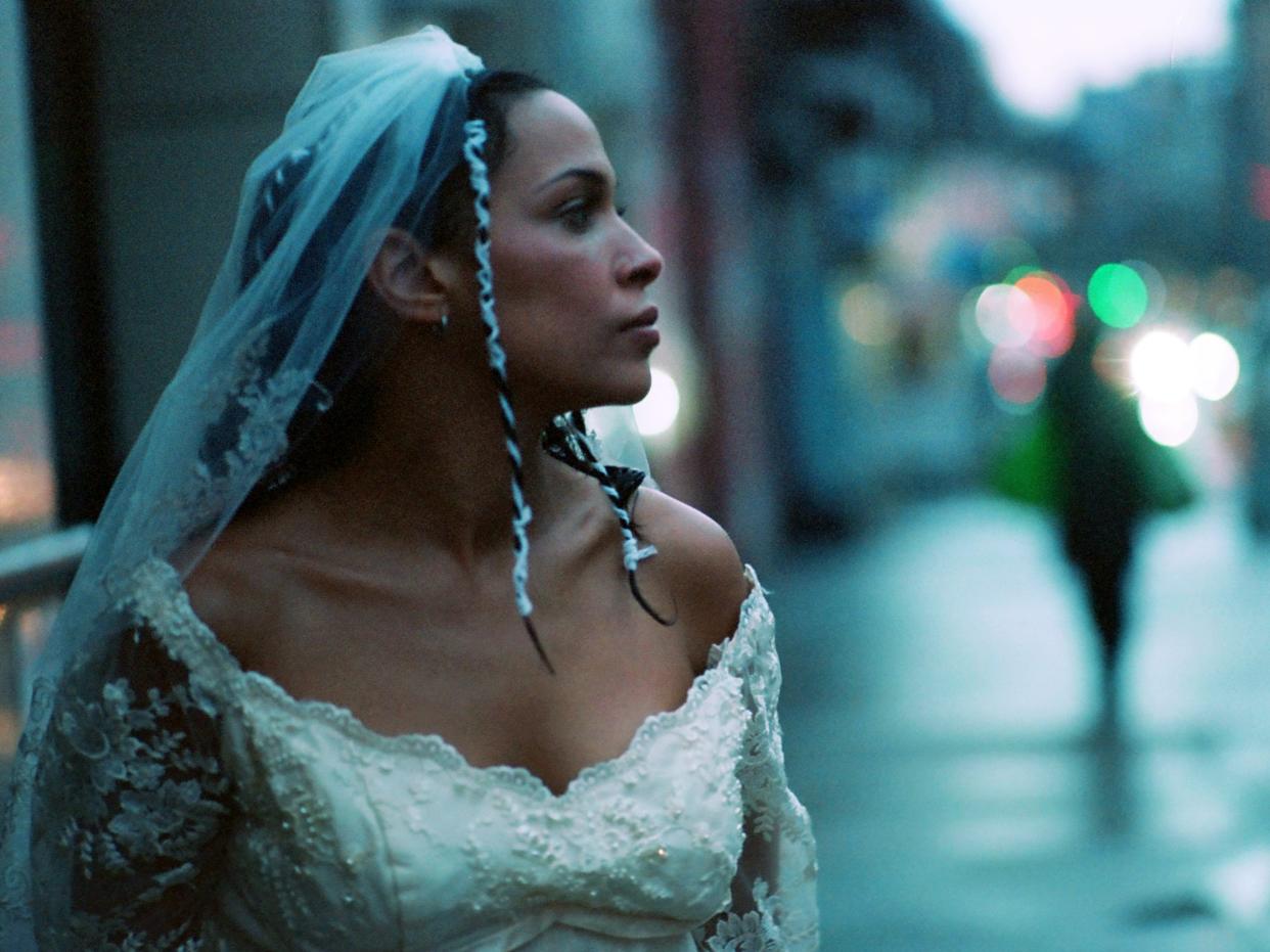 Singer Princess Nokia stands in the streets of New York City in a white wedding dress.