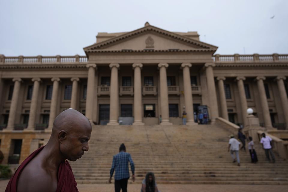 A Buddhist monk who is also a protester stands in front of the president's office as they prepare to leave the premise in Colombo, Sri Lanka, Thursday, July 21, 2022. (AP Photo/Eranga Jayawardena)