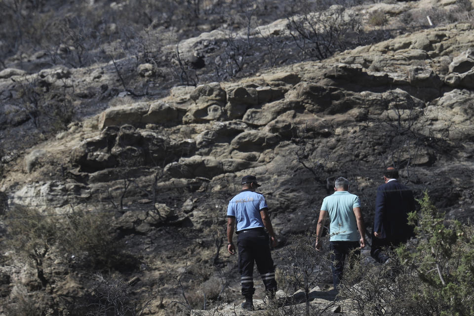 Turkish police patrol the area after an explosion pre-dawn, outside of village of Tashkent in Turkish Cypriot breakaway north part of the divided Cyprus, Monday, July 1, 2019. A Turkish Cypriot official said Monday that a Syrian anti-aircraft missile that missed its target and reached ethnically divided Cyprus may have been the cause of an explosion outside a village in east Mediterranean island notion's breakaway north. No injuries were reported. (AP Photo/Petros Karadjias)