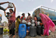 <p>Local residents fill their empty containers with water from a municipal corporation tanker on a hot summer day in Ahmedabad, India, on May 30, 2016. (Amit Dave/Reuters) </p>