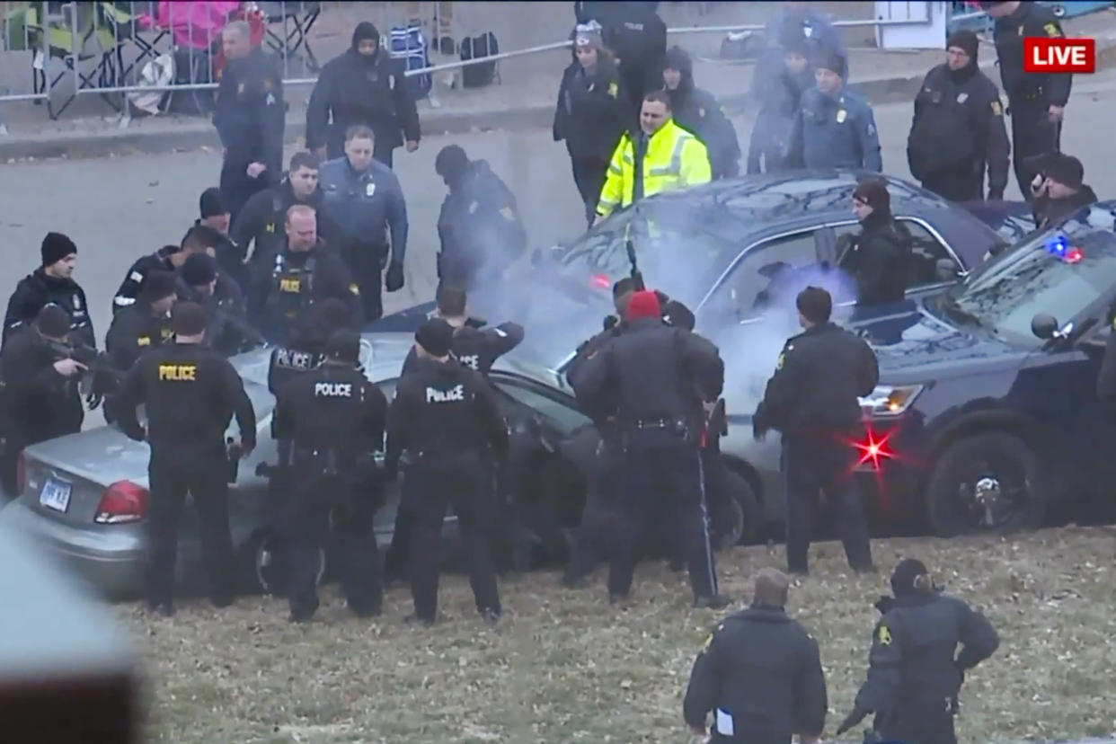 In this image take from video, law enforcement personnel surround a car after it was stopped as the driver approached the crowd near Union Station attending the Super Bowl parade and rally for the Kansas City Chief in Kansas City, Mo., Wednesday, Feb. 5, 2020. (FOXKC via AP)