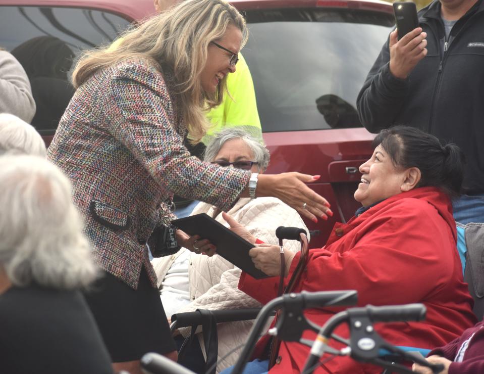 Adrian Mayor Angie Sword Heath, left, reaches out to hug Maria Jiamez Thursday after presenting Jiamez with a city proclamation for her more than 40 years of service to the migrant working community in Lenawee County. Jiamez also is the designer of the Adrian Friends of the Farm Workers flag.