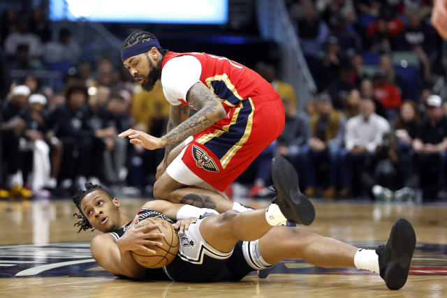 San Antonio Spurs guard Romeo Langford (35) grabs a loose ball in front of New Orleans Pelicans forward Brandon Ingram (14) in the first half of an NBA basketball game in New Orleans, Tuesday, March 21, 2023. (AP Photo/Tyler Kaufman)