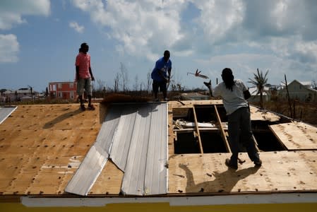 Men work on the roof of a devastated house after Hurricane Dorian hit the Abaco Islands in Treasure Cay