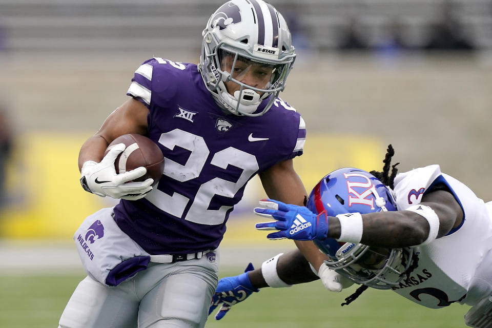 FILE - In this Oct. 24, 2020, file photo, Kansas State running back Deuce Vaughn (22) gets past Kansas safety Ricky Thomas (3) as he runs for a first down during the first half of an NCAA football game in Manhattan, Kan. (AP Photo/Charlie Riedel, File)