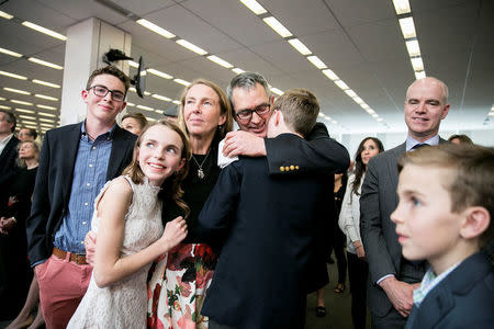 C.J. Chivers (C) embraces his wife and children during a ceremony for the announcement of the 2017 Pulitzer Prizes in The Times office in New York, U.S., April 10, 2017. Sam Hodgson/Courtesy The New York Times/Handout via REUTERS