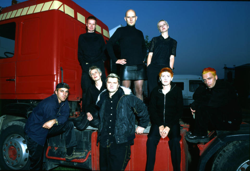 the group poses in front of a semi trunk