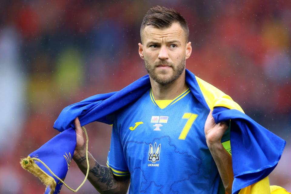 Andriy Yarmolenko of Ukraine lines up on the pitch with their countries flag prior to the FIFA World Cup Qualifier between Wales and Ukraine at Cardiff City Stadium