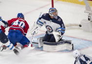 Montreal Canadiens' Joel Armia (40) scores a shorthanded goal on Winnipeg Jets goaltender Connor Hellebuyck (37) as Jets' Josh Morrissey (44) looks on during the second period of an NHL Stanley Cup playoff hockey game in Montreal, Sunday, June 6, 2021. (Ryan Remiorz/The Canadian Press via AP)