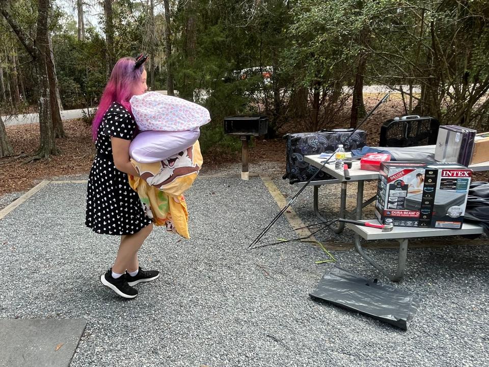 writer carrying stuff to picnic table