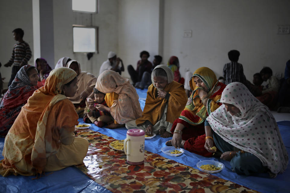 In this Friday, Feb. 28, 2020 photo, Muslim women, who were rescued after their homes were attacked by a marauding Hindu mob, sob while eating a meal inside a hall which doubles as a shelter at Al-Hind hospital in Old Mustafabad neighborhood of New Delhi, India. The hospital in the riot-torn neighborhood turned from a community clinic into a trauma ward, its doctors, for the first time, dealing with injuries like gunshot wounds, crushed skulls and torn male genitals. Authorities haven't said what sparked the violence that has left more than 40 dead and hundreds injured, but it was the culmination of growing tensions since the passage of a citizenship law in December that fast-tracks naturalization for some religious minorities from neighboring countries but not Muslims. (AP Photo/Altaf Qadri)