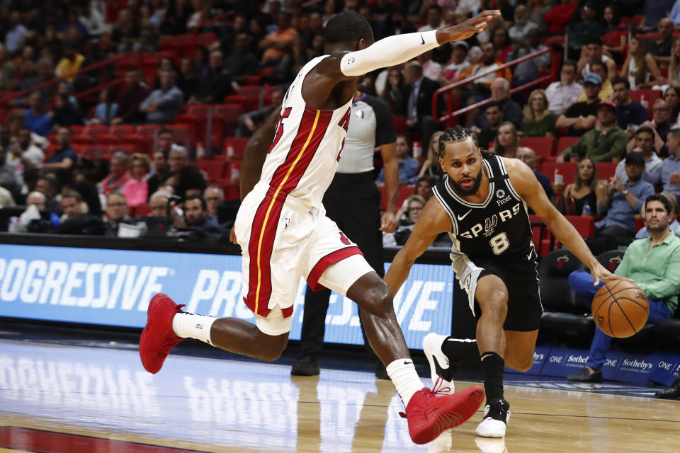 San Antonio Spurs guard Patty Mills (8) dribbles the ball against Miami Heat guard Kendrick Nunn (25) in the first half of an NBA basketball game against the Wednesday, Jan. 15, 2020, in Miami. (AP Photo/Brynn Anderson)