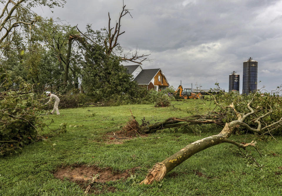 A Kenergy electric cooperative lineman works on a downed power line amidst uprooted trees and a damaged home at U.S. 60 West after a tornado swept through Stanley, Ky., Saturday, Sept. 8, 2018. The tornado caused moderate to severe damage to several homes and damaged cars. (Greg Eans/The Messenger-Inquirer via AP)