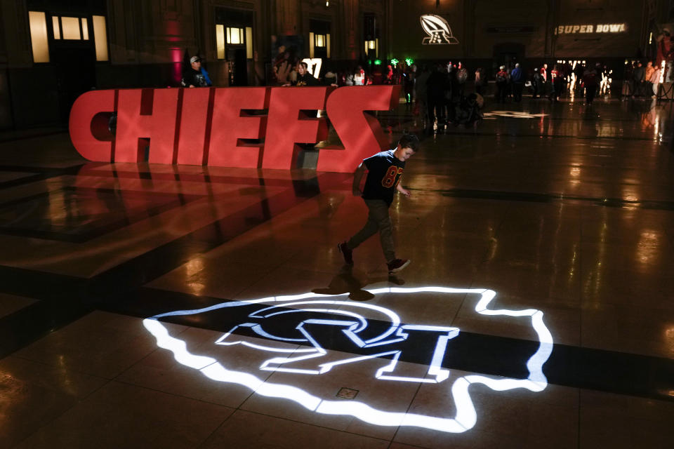 A boy runs across a logo for the Kansas City Chiefs NFL football team while attending a display Thursday, Feb. 9, 2023, at Union Station in Kansas City, Mo. The Chiefs are scheduled to play the Philadelphia Eagles in Super Bowl LVII on Sunday, Feb. 12, 2023. (AP Photo/Charlie Riedel)