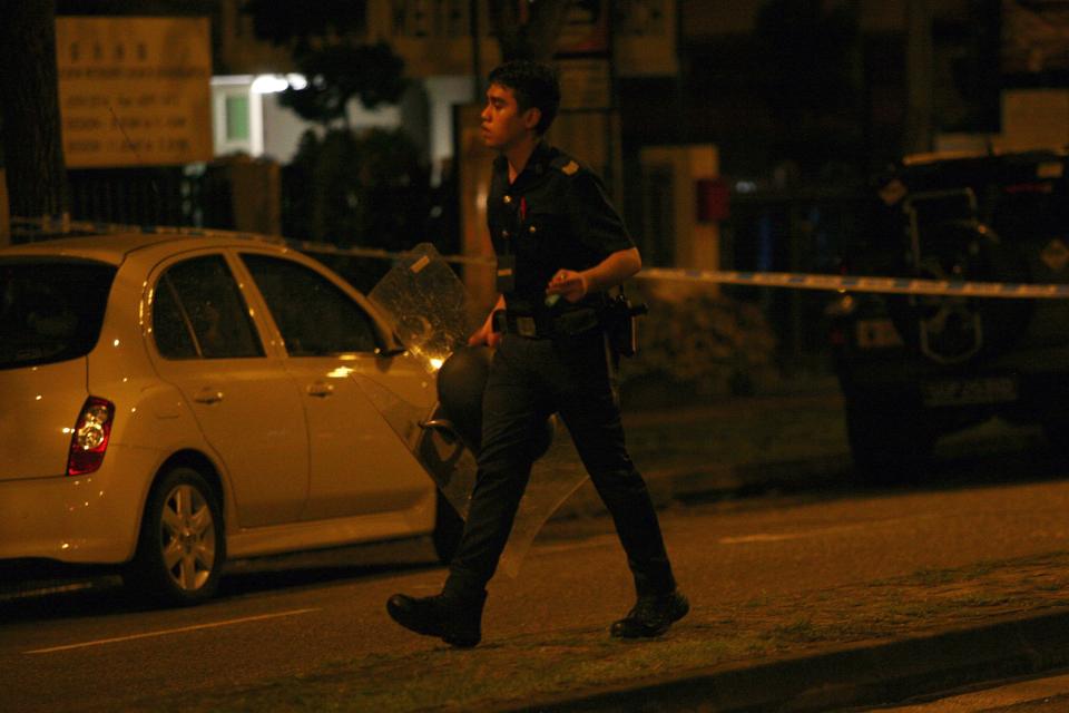 A police officer walks with a riot shield following a riot in Singapore's Little India district