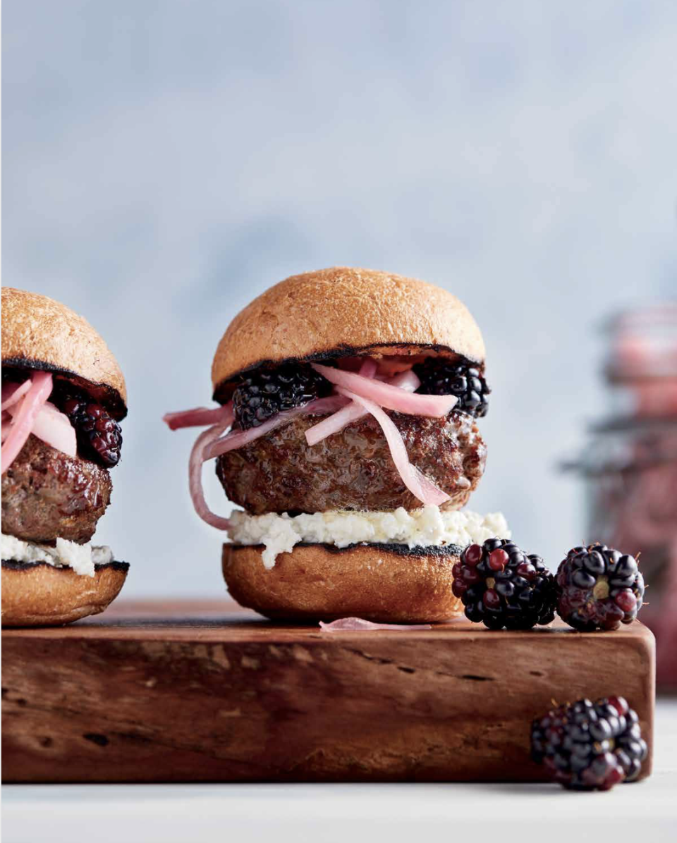 a group of hamburgers with fruit on top