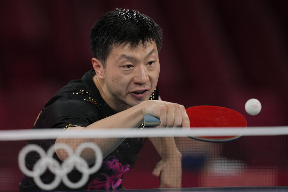 Ma Long of China, top, returns a shot during a gold medal match of the table tennis men's singles against Fan Zhendong of China at the 2020 Summer Olympics, Friday, July 30, 2021, in Tokyo. (AP Photo/Kin Cheung)