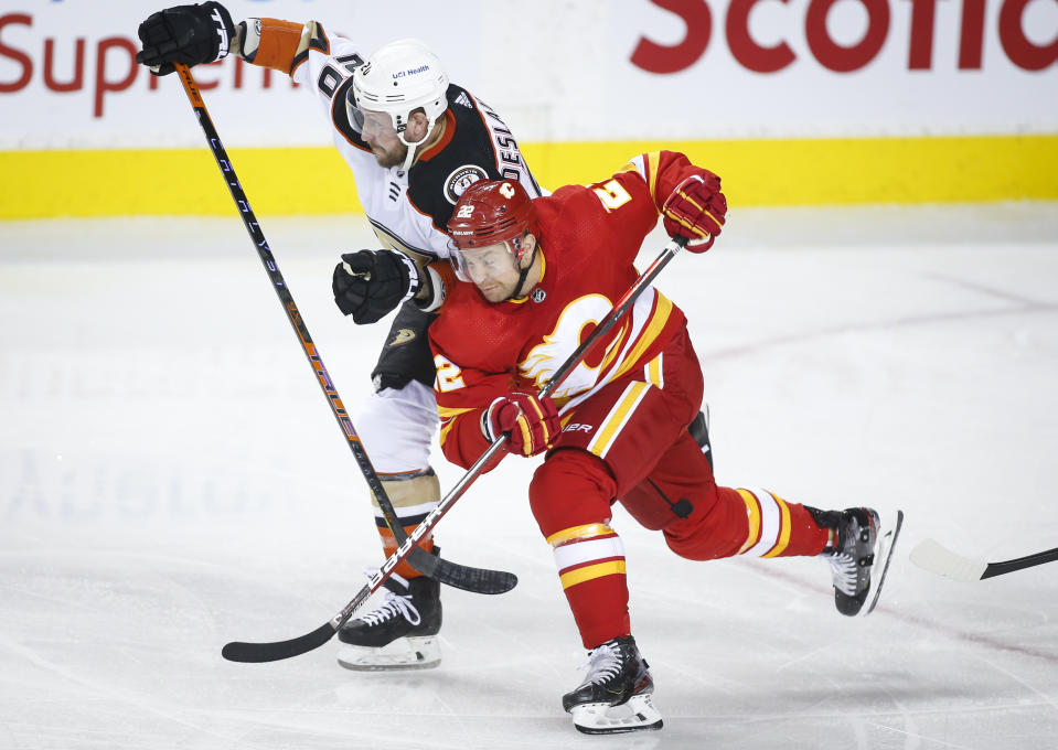 Anaheim Ducks' Nicolas Deslauriers, left, gets past Calgary Flames' Trevor Lewis during the first period of an NHL hockey game, Monday, Oct. 18, 2021, in Calgary, Alberta. (Jeff McIntosh/The Canadian Press via AP)