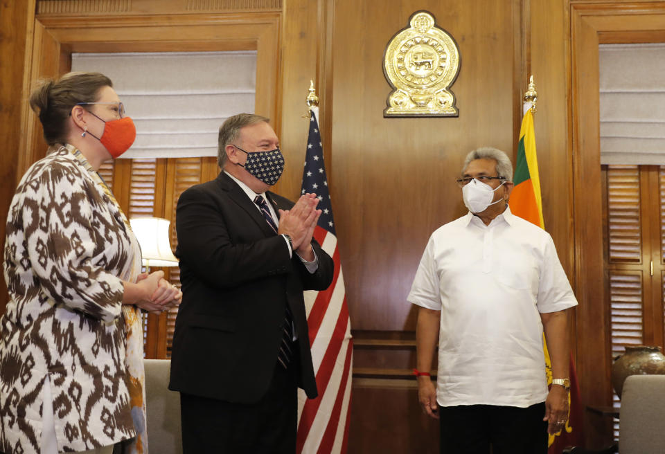 U.S. Secretary of State Mike Pompeo greets the gathering before his meeting with Sri Lankan President Gotabaya Rajapksa, right, in Colombo, Sri Lanka, Wednesday, Oct. 28, 2020. Pompeo plans to press Sri Lanka to push back against Chinese assertiveness, which U.S. officials complain is highlighted by predatory lending and development projects that benefit China more than the presumed recipients. The Chinese Embassy in Sri Lanka denounced Pompeo’s visit to the island even before he arrived there, denouncing a senior U.S. official’s warning that the country should be wary of Chinese investment. (AP Photo/Eranga Jayawardena, Pool)