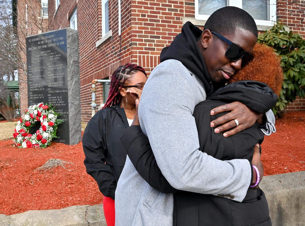 Woodrow Adams Jr., who lost his father, his uncle and his grandmother in February 2021 after a fire at the family home on Jaques Avenue in Worcester, hugs his mother, Lorraine Adams, during a ceremony Tuesday announcing that five new names will be added to a monument commemorating the victims who have lost their lives in city fires since 1986.