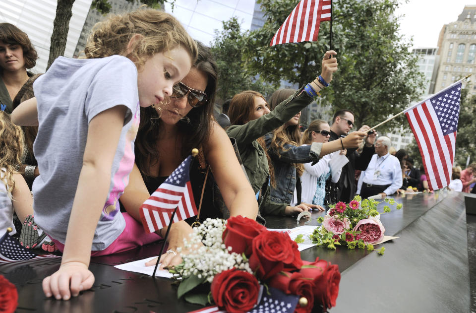 Elle Jackman,6, helps her mother, Iris Jackman, do a rubbing of her aunt's name, Brook Alexander Jackman, on the wall of the north pool of the Sept. 11 memorial during 10th anniversary observance of the terrorist attacks at the World Trade Center, Sunday, Sept. 11, 2011, in New York. (AP Photo/Justin Lane, Pool)