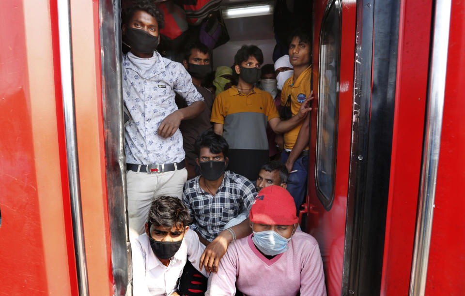 Daily wage laborers, returning from Mumbai travel to their villages amid Coronavirus concerns in a crowded train coach in Prayagraj , India, Sunday, March 22, 2020. India is observing a 14-hour “people's curfew” called by Prime Minister Narendra Modi in order to stem the rising coronavirus caseload in the country of 1.3 billion. For most people, the new coronavirus causes only mild or moderate symptoms. For some it can cause more severe illness. (AP Photo/Rajesh Kumar Singh)