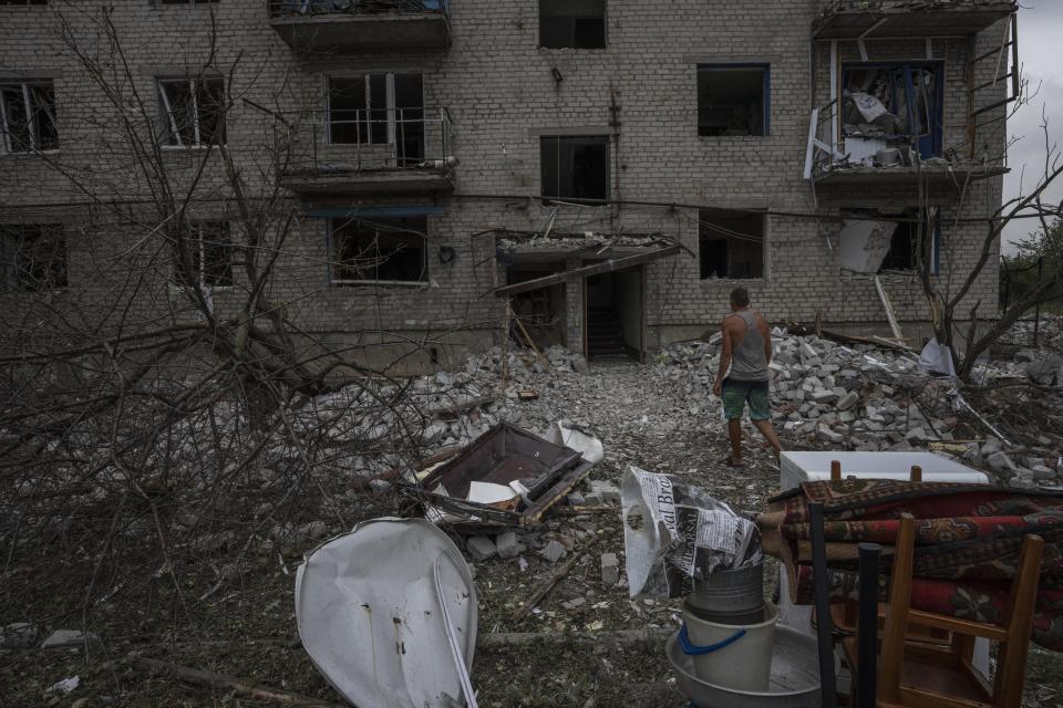 A resident salvages what he can from his home, after a rocket hit an apartment residential block, in Chasiv Yar, Donetsk region, eastern Ukraine, Sunday, July 10, 2022. At least 15 people were killed and more than 20 people may still be trapped in the rubble, officials said Sunday. (AP Photo/Nariman El-Mofty)