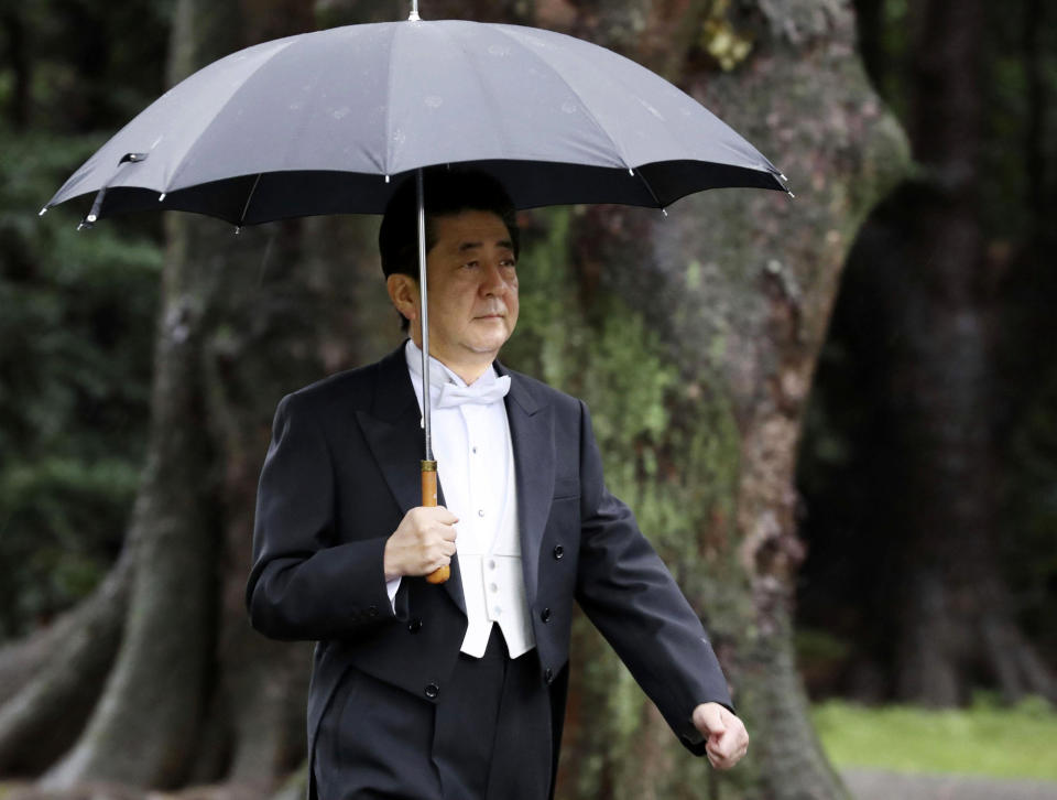 Japan's Prime Minister Shinzo Abe arrives for the ceremony at "Kashikodokoro", one of three shrines at the Imperial Palace, in Tokyo, Tuesday, Oct. 22, 2019. Emperor Naruhito and Empress Masako visited three Shinto shrines at the Imperial Palace before Naruhito proclaims himself Japan’s 126th emperor in an enthronement ceremony. (Kyodo News via AP)