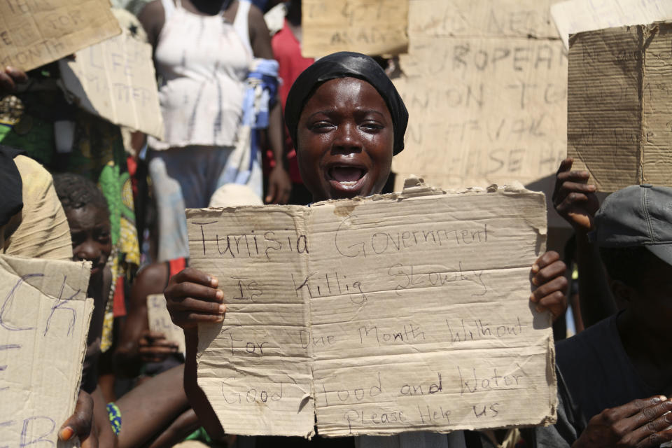 African migrants protest on the Libyan border with Tunisia on Thursday, Aug. 4, 2023. The Tunisian security forces reportedly expelled hundreds of migrants over the border into Libya, where they have been stranded in scorching summer temperatures without water and food since June. (AP Photo/Yousef Murad)