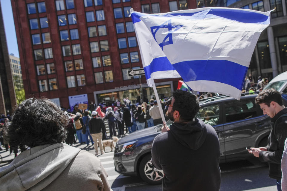 FILE - New York University students and pro-Israeli supporters rally across the street from pro-Palestinian students and supporters outside the NYU Stern School of Business building, Monday, April 22, 2024, in New York. Some NYU students facing discipline for their actions during this spring's pro-Palestinian protests have been assigned a 49-page workbook that includes a "Simpsons"-based module on ethical decision making. Some have been asked to write an apologetic "reflection paper" and submit it "in 12-point Times New Roman or similar font." (AP Photo/Mary Altaffer, File)