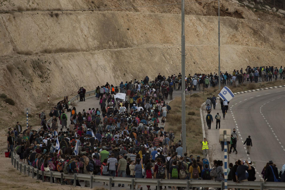 Israelis march from the West Bank settlement of Maaleh Adumim, to the E-1 area on the eastern outskirts of Jerusalem, Thursday, Feb. 13, 2014. Israel planned construction in the area E-1, or East 1, but froze under the international pressure in 2009. The construction in the area would effectively separate Palestinians in east Jerusalem from the West Bank. (AP Photo/Sebastian Scheiner)