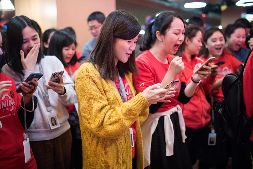 HANGZHOU, CHINA - NOVEMBER 12: Alibaba employees look at their cellphones during celebrations at Alibaba's Xixi base after Alibaba Group's 11.11 Global Shopping Festival on November 12, 2018 in Hangzhou, Zhejiang Province of China. The gross merchandise volume (GMV) of 2018 Alibaba Group's 11.11 Global Shopping Festival surpassed 213.5 billion yuan (about 30.7 billion US dollars) on Sunday. (Photo by VCG/VCG via Getty Images)
